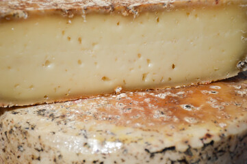 a cut of a head of goat cheese on a display case