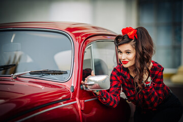Girl in red clothes near a red car