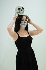 Adolescente joven con una carabela festejando el dia de Halloween vestida de negro y maquillada...