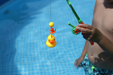 ni&ntilde;o jugando con patitos en la piscina, juego de pescar