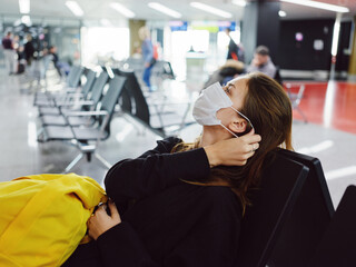 passengers medical mask airport waiting for flight yellow backpack