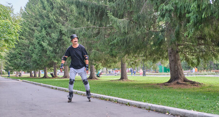 Active senior asian man is roller skating in park.