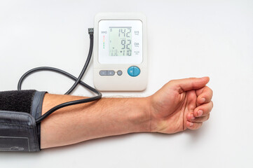Person measures their own blood pressure at the medical table. Taking care of your own health