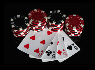 Obraz premium Poker game with four of a kind or quads combination. Chips and cards on the black table. Successful and win.