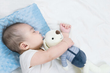 Selective focus portrait of a sleeping Charming baby Cute newborn sleeps with a toy teddy bear on comfortable bed