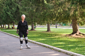 Active senior caucasian woman with gray hair is roller skating in park.