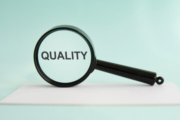Inscription quality on magnifying glass, blue background