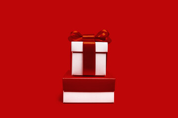 Two assorted red and white gift boxes on red background. different size. Merry Christmas and Happy...