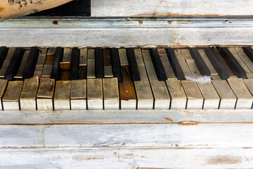 Fototapeta na wymiar Damaged keys of an old piano with a pen