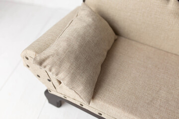 Fototapeta na wymiar soft beige pillow on the sofa. furniture for dolls