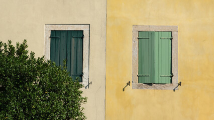 Fototapeta na wymiar An italian yellow house with green shutters