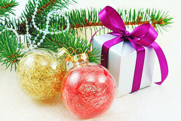 Christmas decorations with Silver gift wrapped present with purple satin bow on a glitter tulle background