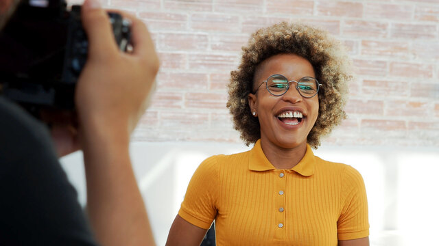 Smiling afro model woman posing for a fashion photographer