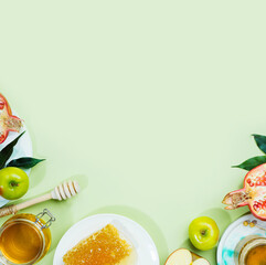 Honey, apple and pomegranate on a mint-green background. Concept Jewish New Year Happy holiday Rosh Hashanah. Creative layout of traditional symbols. View from above. Flat lay. Copy space. Shana Tova.