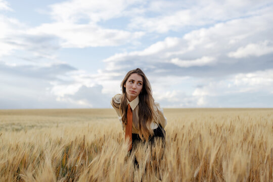 Millennial woman among wheat spikes in field