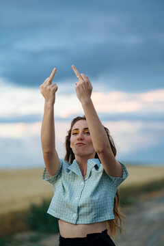 Rude woman showing fuck gesture on countryside roadway