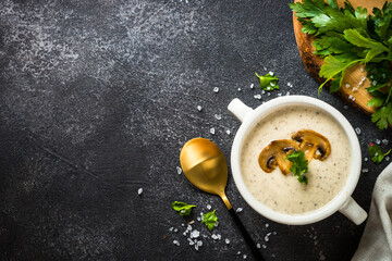 Mushroom Soup on dark stone table. Hot autumn dish, creamy soup.