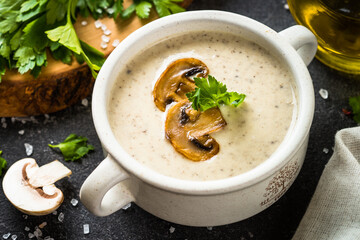 Mushroom Soup on dark stone table. Healthy vegan dish. Autumn soup.