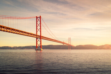 Modern bridge over river at sunset