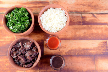 Obraz na płótnie Canvas typical Brazilian food feijoada made with beans, pork, bacon, sausage with cabbage, rice, salad, spices and pepper.