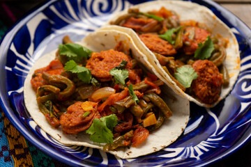 Mexican food. Chorizo and nopales tacos on wooden background