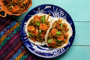 Mexican food. Chorizo and nopales tacos on turquoise background