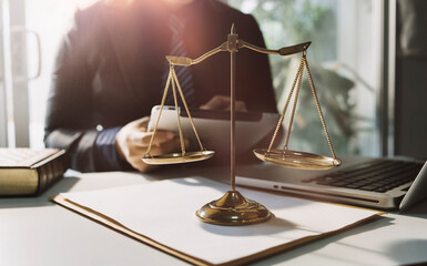 Justice and law concept.Male judge in a courtroom with the gavel, working with, computer and docking keyboard, eyeglasses, on table in morning light