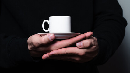 A coffee mug in men's hands. 