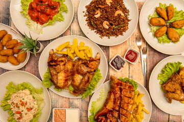 Food plates for tapas restaurant. Roast chicken with french fries, chaufa aroz, tiger mussels, ham croquettes, meatloaf with tomato, Russian salad, barbecued ribs