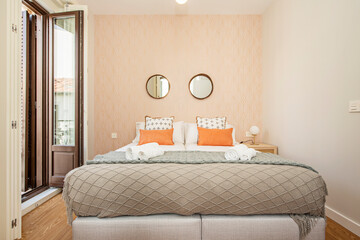 bedroom with king size bed and beautiful decoration with window facing the street and circular mirrors over the headboard in a bedroom for vacation rental