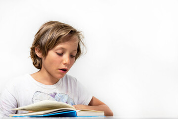 stylish boy reading an interesting book on a white background, back to school, education.