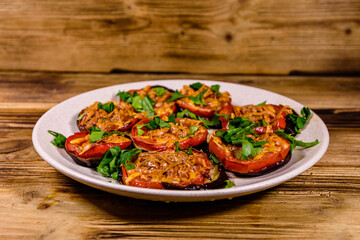 Baked eggplants with tomatoes and cheese in a ceramic plate
