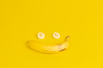 Closeup of a smiley face formed with a banana isolated on a yellow background
