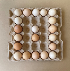Overhead view of free-range organic chicken brown eggs in tray. Background with chicken eggs. Eggs for Easter. Background for cafes, restaurants, fast food outlet. Craft background.