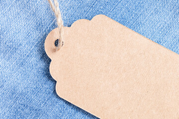 Craft tag, label on blue denim jeans background, copy space