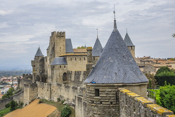 Fragments of outer wall (13th century) and towers of the Carcassonne medieval citadel on a hill on...