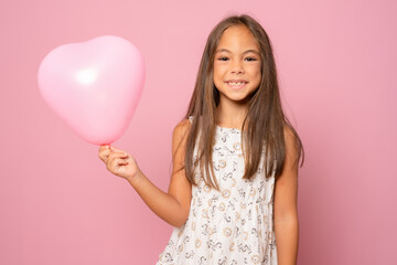 Beautiful little girl with pastel pink air balloon isolated over pink background.