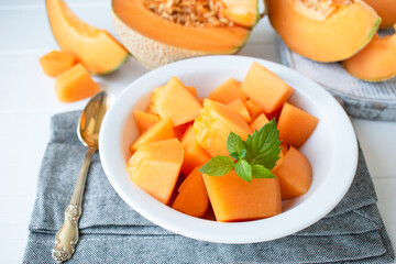 pieces of melon on a plate on a concrete table