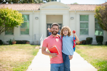 American father and son walking trough school park.