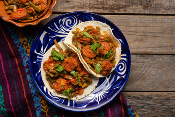 Mexican food. Chorizo and nopales tacos on wooden background