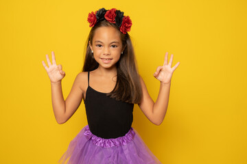 Beautiful little girl in Halloween costume isolated over yellow background.Halloween, carnival, childhood, fairytale theme.