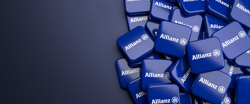 Logos of the German insurance and financial services group Allianz on a heap on a table. Copy space. Web banner format.