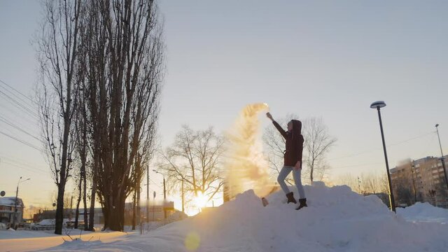 Slow motion: woman in burgundy jacket throwing hot water from mug in cold air at low temperature, warm water turning to steam - Mpemba effect. Experiment, science, winter outdoor leisure time concept
