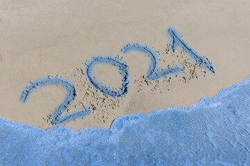 2021 sign and symbol written text on the beach sand word