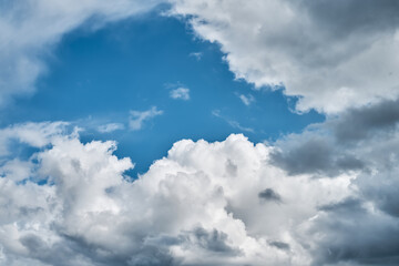 Fluffy storm clouds against the bright blue sky. Nature background. Copy space