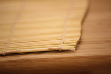 Homemade sushi roll preparation on a bamboo mat – in progress 