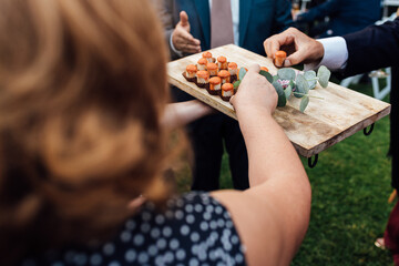 People taking snacks from the waiter during a party. Catering service and food concept.