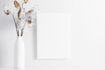 White canvas mockup with shadow and vase with dry flower decoration.