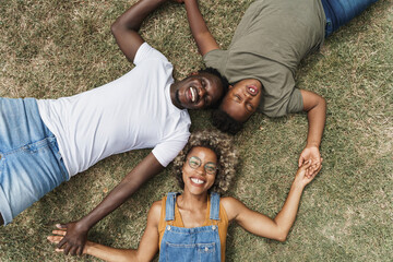 Top down black Family lying on the grass. Happy smiling Young African American parents in love with their son