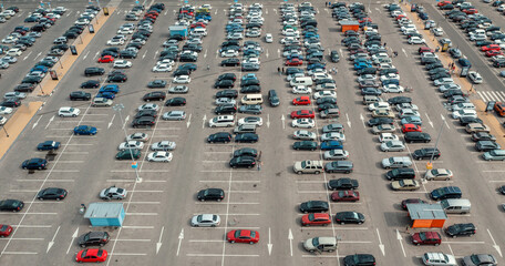 Fototapeta premium Shopping mall parking lot with many cars, aerial top view from drone.